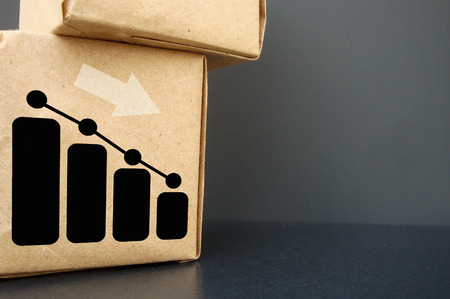 On a dark background a box. It shows the graph going down. Business graph falls.の写真素材
