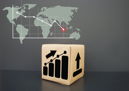 On a dark background a box. It shows a graph going up. Business graph rises.の写真素材