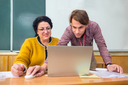 Young generation instruct teachers, elder people. Multi generation business forum. Education concept. New generation helps elder one with new technologies.の写真素材