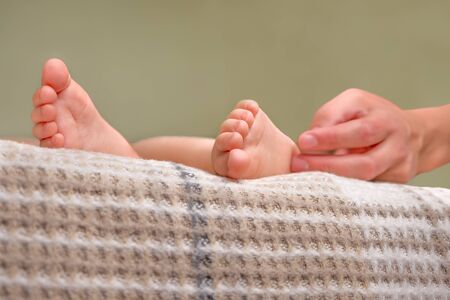 Childrens feet. Barefeet on the bed. Kids feet in bed. Tickling for fun. Kids taking a rest focus on...