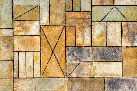 Background of he wall is tiled with different sizes. Beige tile forms an attractive geometric pattern. Background of ancient geometric ornamentの写真素材