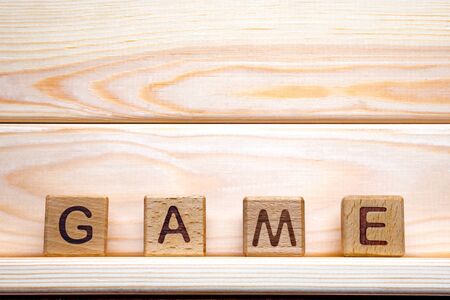 Wooden cubes with letters. Game word on wooden background. Play video games. Gamer concept. Banner, template, mock up, advertisingの写真素材
