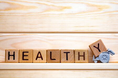 Word healthy written with wooden cubes. Healthy lifestyle. Preventive medicine background. Assisting with medication. Care at home. Healthcare background. Healthy concept.の写真素材
