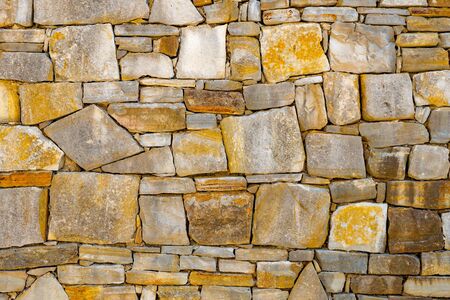 Wall of stones as a texture. Stone wall. Wall of stones. wall of a medieval fortress with mainly white or light colored stones of varying sizes and shapes, usable as background pattern or for designsの写真素材