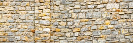 Stone wall banner. Wall of stones as a texture. Wall of stones. wall of a medieval fortress with mainly white or light colored stones of varying sizes and shapesの写真素材