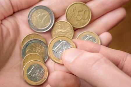 Money in hand. Cash, coins in palm of hand. Counting coins. Bank concept. Social issues. Economic...