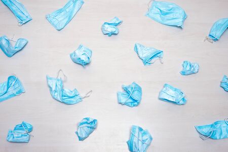 Used medical mask thrown away. Utilization of protection during coronavirus. Protective facemasks scattered on the floor. Background of used medical masks. Infectious waste background. Used facemasksの写真素材