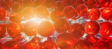 Banner of bottled red beverage. Many glass bottles of rose wine with sunlight breaking through the...