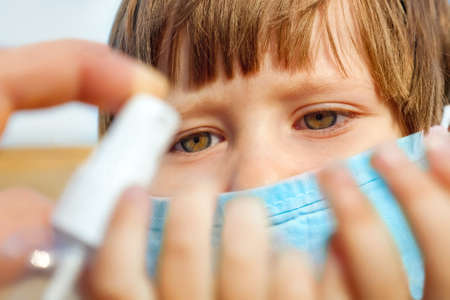 Coronavirus, covid-19 outbreak. Little girl in medical mask with hands waiting to be sanitized. Clean hands concept. Virus, bacteria, epidemic outbreak. Quarantine concept. Health care for kidsの写真素材