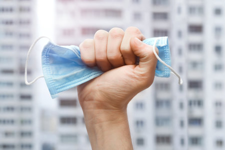 New normal. End lockdown. Victory hand mask. Pandemic end. Recovery from illness. Mask in fist. End coronavirus. Quarantine is over. After Covid-19. Victory coronavirus. Stop Covid-19. Fight to virusの写真素材