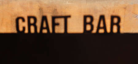 Design flyer and poster for local restaurants with words craft bar inscription in retro or vintage style and icon. Shadow letters written CRAFT BAR on yellow and black grangy old cracked wall bannerの写真素材