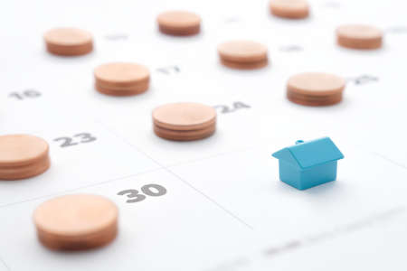 Mortgage property rent payments in installments loan house model. Family budget home mortgage payment due on end of month calendar with coins stack for saving money plan household expenses utilitiesの写真素材