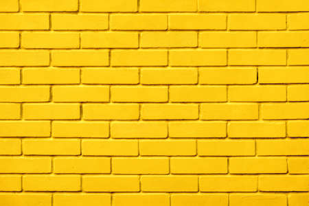 Painted bricks design yellow color wall background blocks. Natural design texture background yellow brick wall color paint block pattern. Block texture yellow painted wall brick background warm colorの写真素材