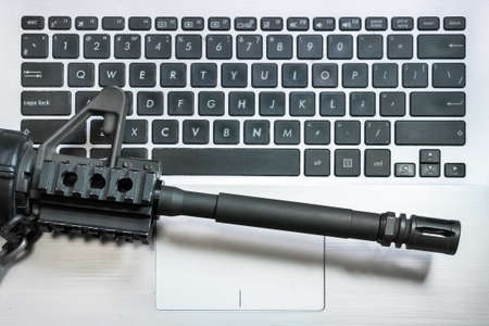 Cyber Warfare. Machine gun on keyboard computer. Fake news. Hybrid war media influence public...