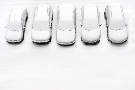 Cover winter parking lot cars under snow covered cars winter season. Snowy row of cars snow background winter time. Top view. Cold weather. Snowbound, Snow weather conditions. Above view. White designの写真素材