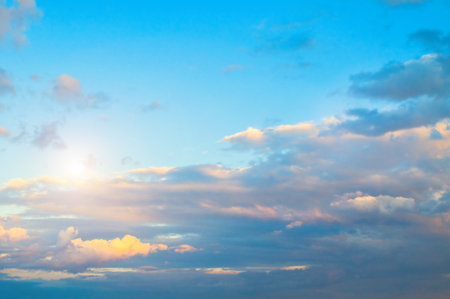 Blue dramatic sky background - sunset dramatic colorful clouds lit by sunlight. Vast sky landscape panoramic scene with rays of lightの写真素材