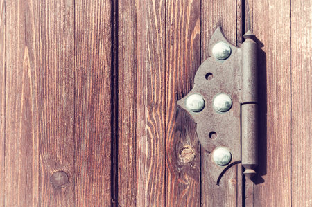 Wooden weathered door with old metal door hinge, architecture background