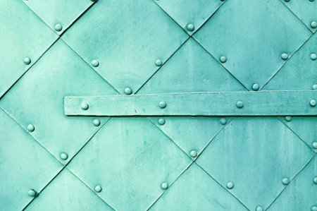 Metal light green surface of old hammered metal plates with rivets and architectural details on...
