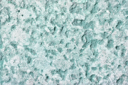 Detailed surface of stone light green wall with fine grooves - textured background.