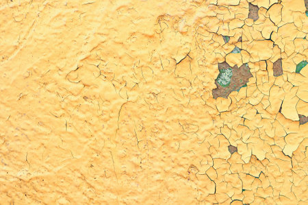 Textured background - bright yellow and green peeling paint on the old rough concrete surfaceの写真素材