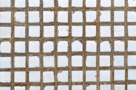 Textured background - small white ceramic tile on the concrete wall