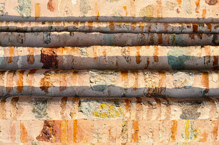 Old textured architectural background. Ribbed wall made of thin calcined brick known as plinfa which...