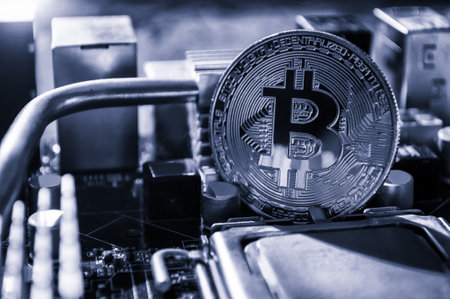Silver bitcoin among the electronic computer components. Business concept of digital cryptocurrency....