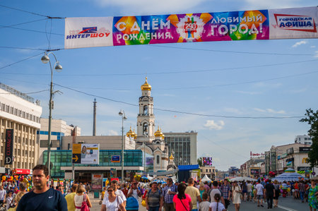 YEKATERINBURG, RUSSIA - AUGUST 17, 2013. City Day celebrations in Yekaterinburg - people walking on the street under a festive banner with the inscription Happy birthday, favorite cityのeditorial素材