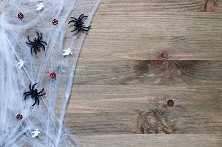 Halloween background with spider web, spiders and ghosts as symbols of Halloween on the wooden background. Halloween border with free space for textの写真素材