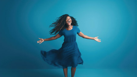 Young beautiful hispanic woman wearing casual blue dress celebrating happy and crazy for success with arms raised and open eyes screaming excited. cheerful concept.の素材