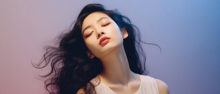 Beautiful young Asian woman with long black hair on blue background.の素材