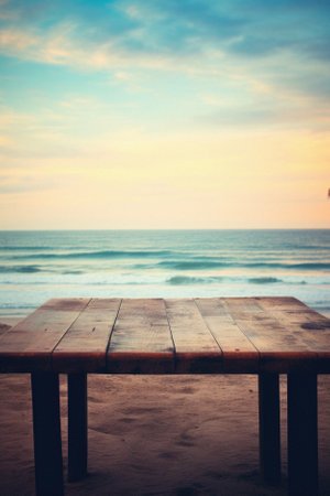 Wooden table ocean bokeh background, empty wood desk surface product display mockup with blurry sea water sunny beach abstract summer travel backdrop advertising presentation. Mock up, copy space.の素材