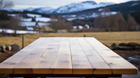 Wooden table mountains bokeh background, empty wood desk surface product display mockup with blurry nature hills landscape abstract travel backdrop advertising presentation. Mock up, copy space.の素材