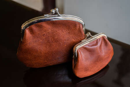 Two brown radicals small and large. Handmade leather wallets of different sizesの写真素材