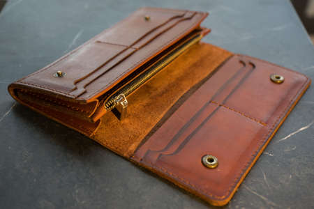 U-turn brown handmade leather wallet. Brown leather purse on a dark background