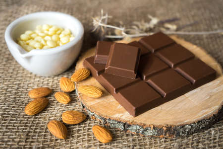 chocolate with cocoa butter and almonds on woodの写真素材