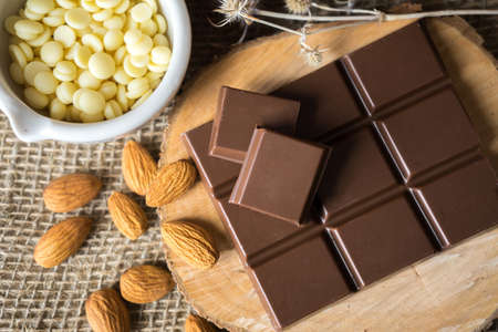 chocolate with cocoa butter and almonds on woodの写真素材