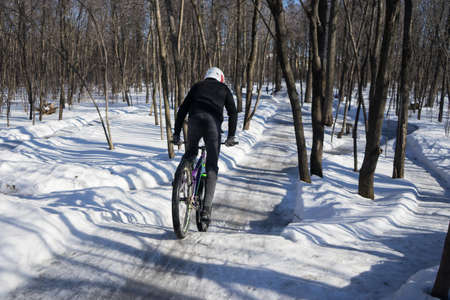 rider rides on a pump track in winter. The cyclist accelerates to jump on dirt jumping. slippery pump track in winter in snow. High quality photoの写真素材