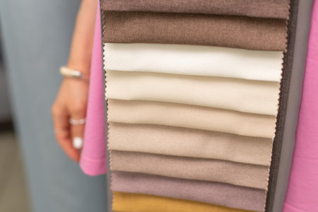 The girl is holding samples of colorful fabric for curtains and home textiles. Samples of textiles for curtains.の写真素材