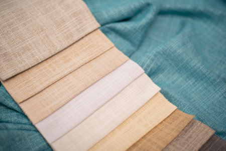 Milk and beige samples of fabrics for curtains on a turquoise background. Linen fabric.の写真素材