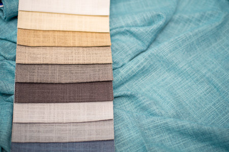 Beige and gray samples of fabrics for curtains on a turquoise background. Linen fabric.の写真素材