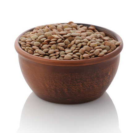   bowl of dried brown lentils on a white background isolateの写真素材