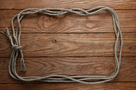 frame of rope on the background of wooden boardsの写真素材
