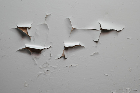 Old cracked gray paint on the wall surfaceの写真素材