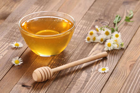 honey in a glass bowl on the background of wooden boardsの写真素材