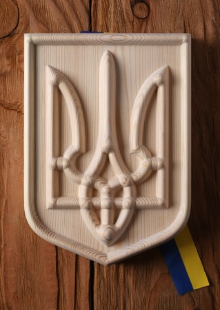 Coat of arms of Ukraine (state emblem, national ukrainian )  carved from a tree on a white...