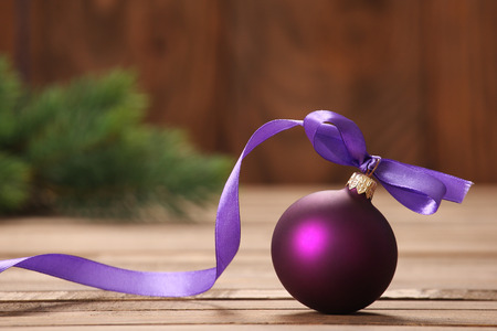 Christmas Toy purple ball with ribbon on a background of boardsの写真素材