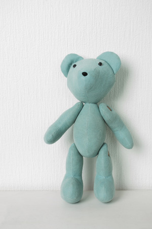 Teddy bear on a white wall background with space for textの写真素材