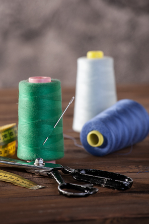 spools of thread, scissors on the background of wooden painted boardsの写真素材