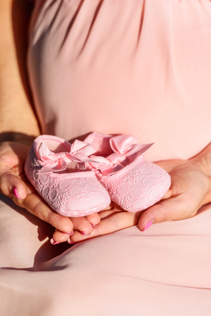 First baby girl shoes in a parent handsの写真素材